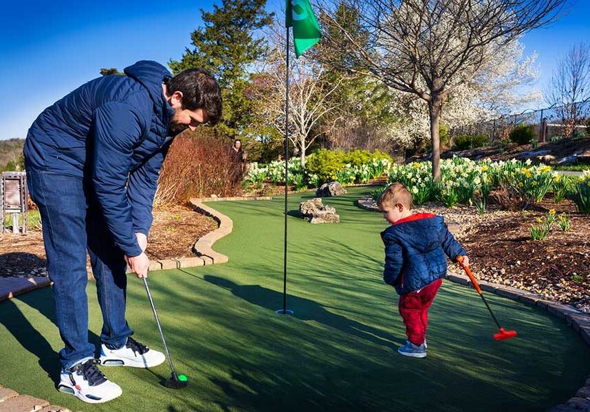 A father and young boy play mini golf at the Big Bass Mini golf course at Big Cedar Lodge