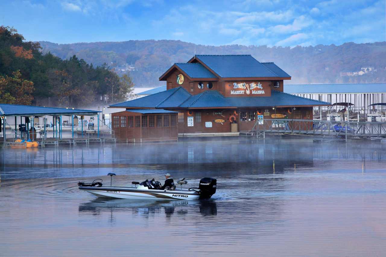 Boat on the lake with marina and fog in the background