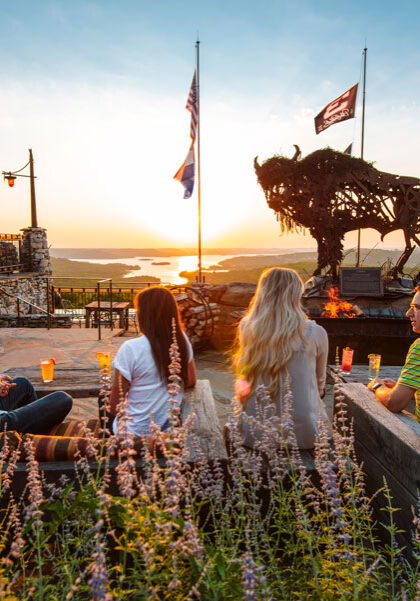 Couples on the patio at Buffalo Bar enjoying outdoor casual dining with view of the valleys and Table Rock Lake at Top of the Rock at Big Cedar