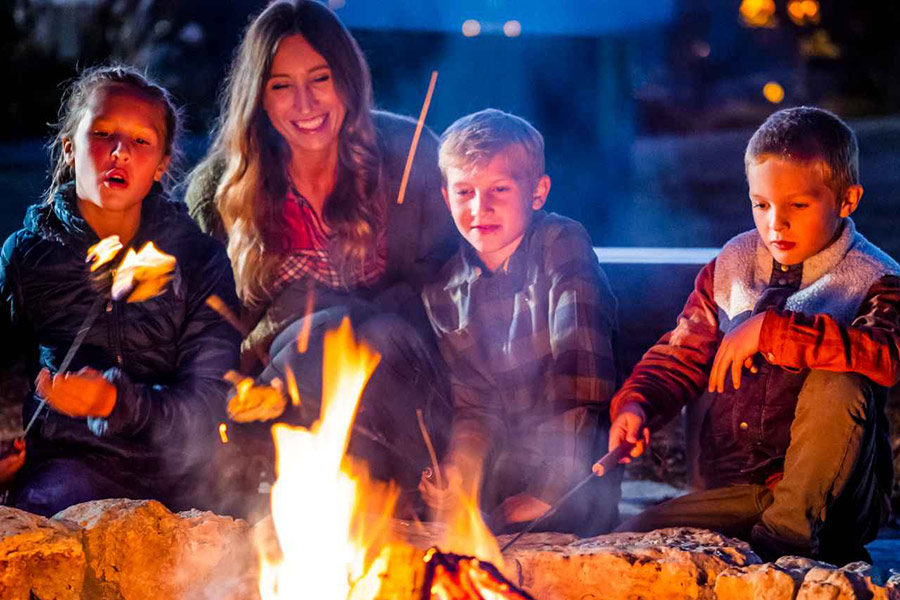 Big Cedar Lodge Bonfire Family sitting near campfire roasting marshmellows