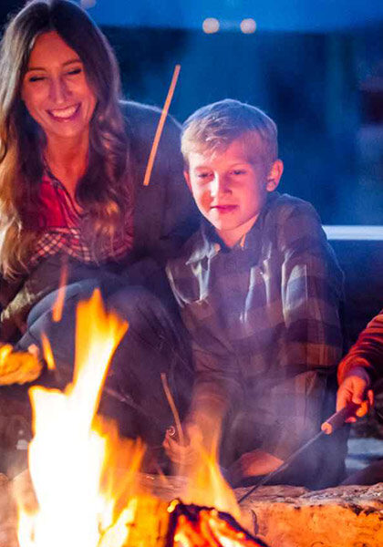 Big Cedar Lodge Bonfire Family sitting near campfire roasting marshmellows