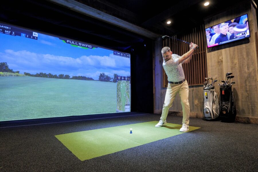 Full HD JPG-2025_BigCedarLodge_Fun Mtn_Activites_Lucky Putt00015 man swings at the golf simulator at fun mountain