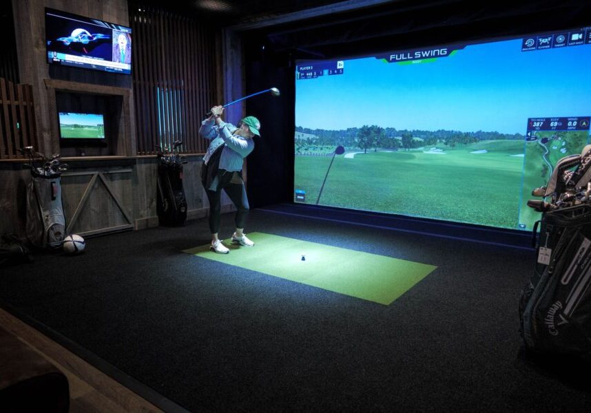 guest swings at the golf simulator at fun mountain