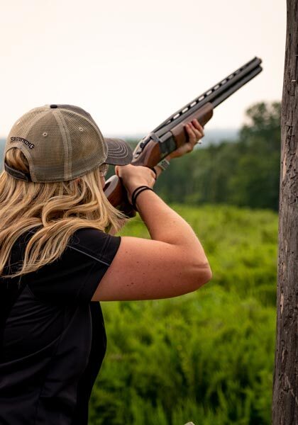 Woman shooting clays at Bass Pro Shops Shooting Academy at Big Cedar Woman shooting clays at Bass Pro Shops Shooting Academy at Big Cedar