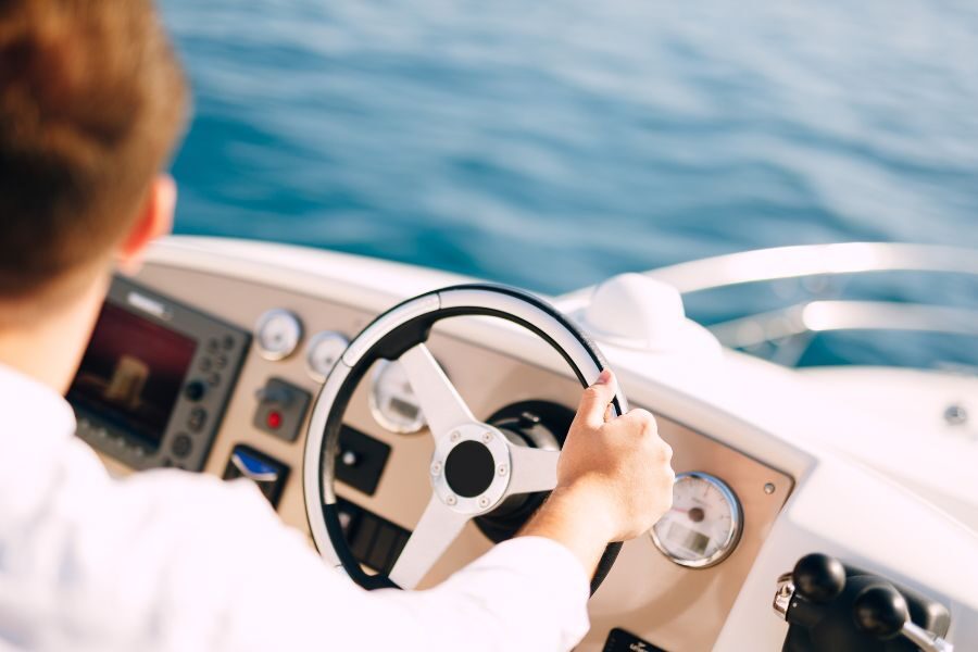 Boat Captain Inquiry A boat captain guides her motorboat through calm blue waters.